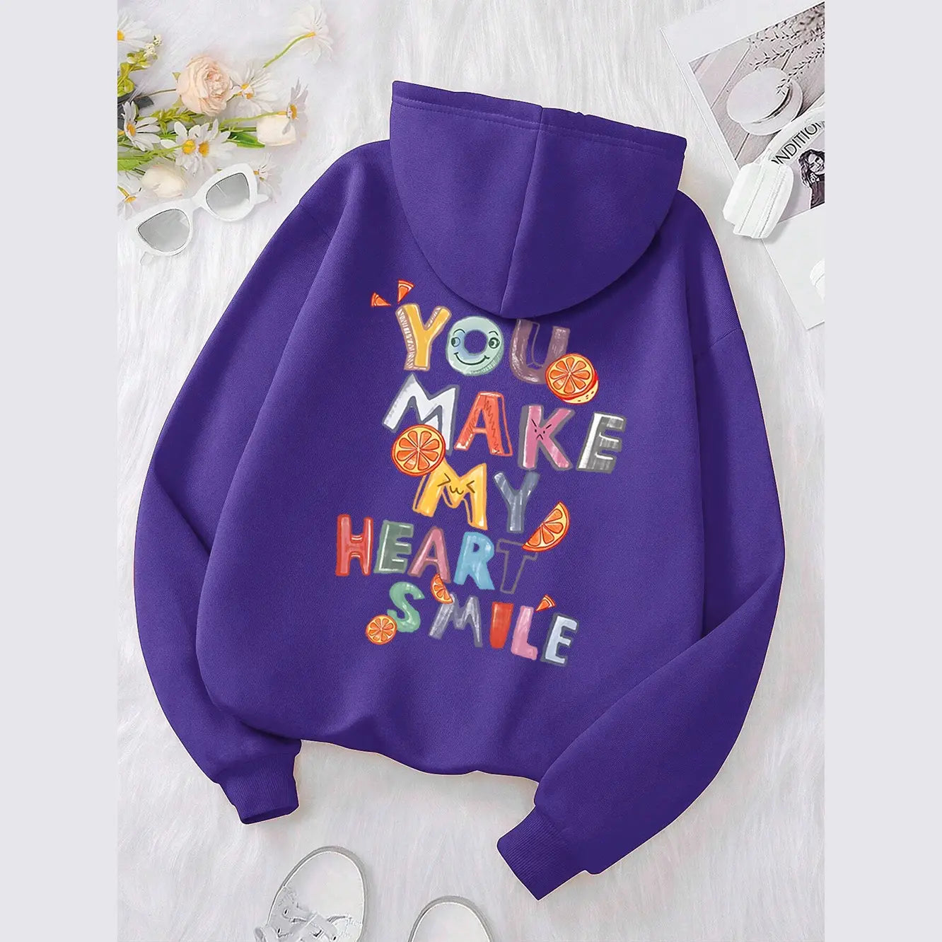 Sweat à capuche violet avec un motif brodé coloré « You make my heart smile » comprenant des tranches d’orange et un visage souriant, pour un usage décontracté.