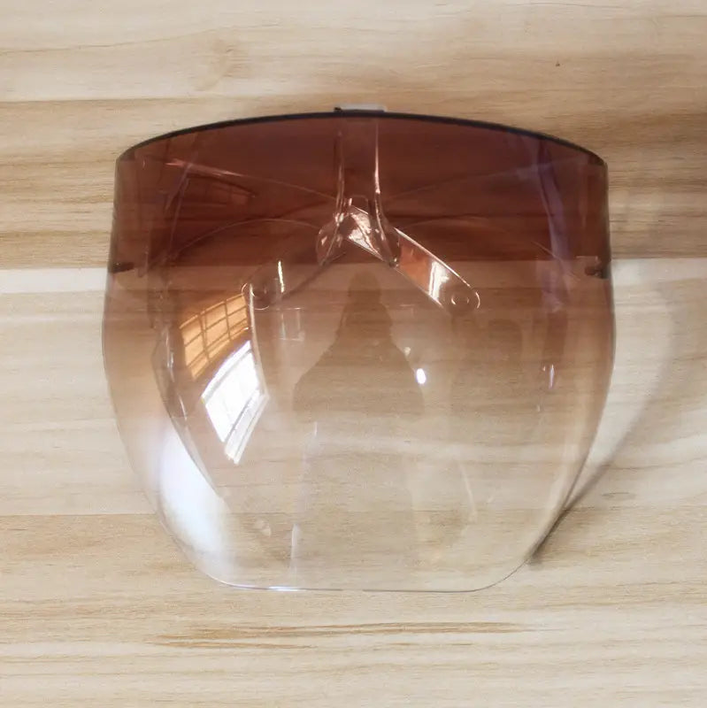 A multifunctional anti-splash iridescent shield sunglasses featuring a transparent face shield with a gradient brown tint and metallic frame.