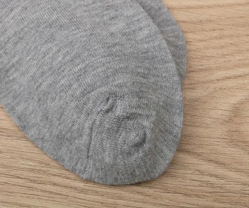 Men mid calf crew sock in soft heather gray with ribbed texture and neatly stitched toe shown from the front.