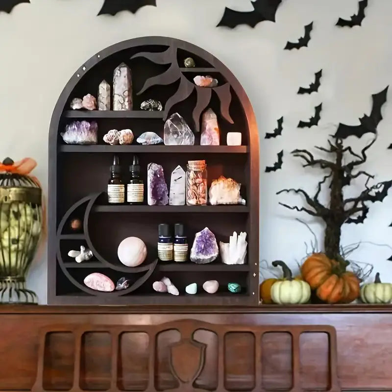Dark wooden arched sun floating shelf with intricate sun and moon cutout designs displaying crystals minerals essential oil bottles and decorative items.