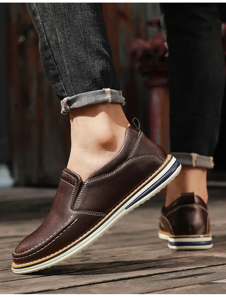 Braune Lederschlupf-Loafer zeichnen sich durch handgenähte Verarbeitung aus und verfügen über eine weiße sowie dunkelblaue Streifensohle, ideal für den legeren Gebrauch.