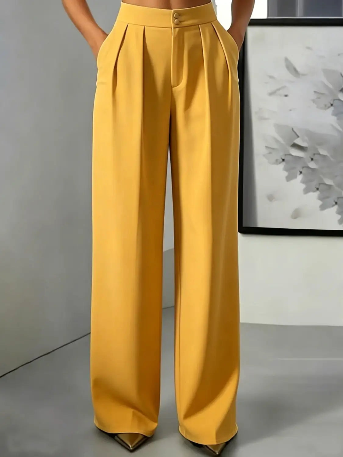 Pantalons moutarde à jambes larges et taille haute, avec un devant plissé élégant et une fermeture à boutons, parfaits pour une tenue formelle et décontractée.