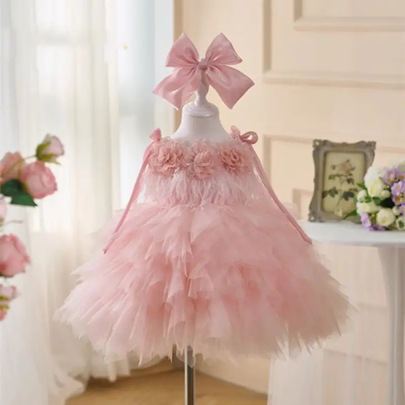 Robe de cérémonie de fille d’honneur en tulle floral rose à tutu, délicate, ornée d’éléments décoratifs floraux et d’un bandeau noué assorti.