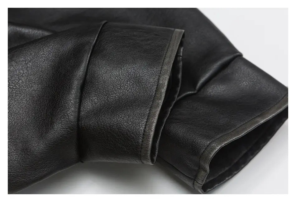 Schwarzer Ärmel einer Biker-Bomberjacke aus Kunstleder mit glatter, leicht strukturierter Oberfläche und ordentlich genähten Kanten, mit Utility-Taschen.