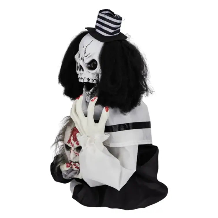 A spooky halloween animatronic scary clown decoration 1.8ft tall with a white skull face black curly hair striped top hat and black-and-white outfit holding a bloody doll head is sound activated.