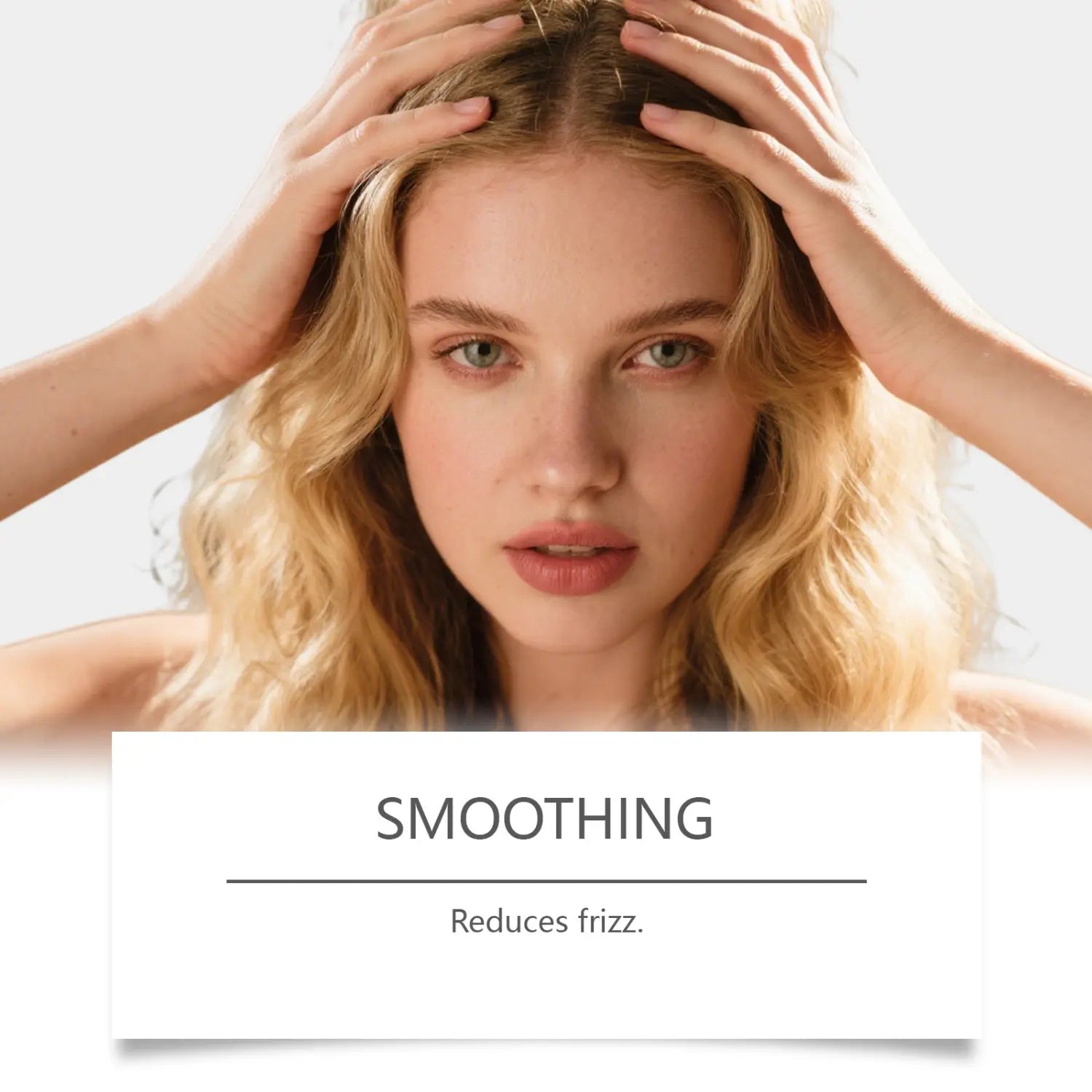 Eine Frau mit welligem blondem Haar und grünen Augen, mit den Händen auf dem Kopf, die die Anwendung von Batana-Öl-Shampoo für blondes und welliges Haar (55 ml) veranschaulicht.