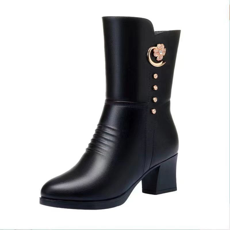 Black leather women’s martin ankle boot with gold-toned clover and crescent moon embellishment accented by four matching studs along the side.
