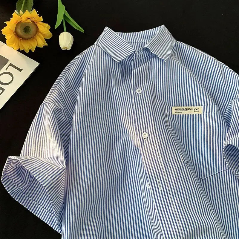 Plus size striped casual shirt in blue and white vertical stripes with short sleeves, a collar, button-up front, and a small rectangular new fashion label on the left chest pocket.