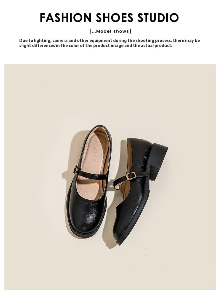 Black leather mary jane shoes with a black patent leather finish, low block heel, and gold-toned buckle.