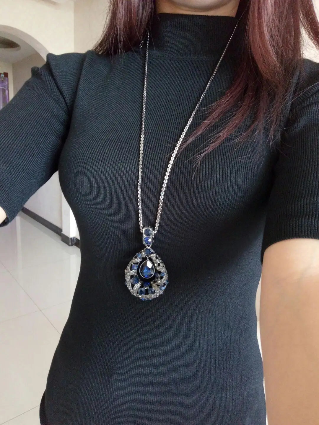 Elegant silver blue teardrop filigree pendant necklace featuring a deep blue gemstone surrounded by sparkling clear crystals on a Korean style sweater chain.