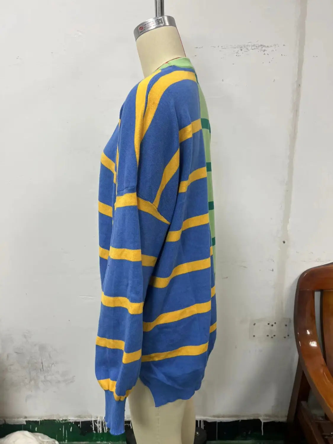women’s oversized split color striped knit sweater in blue and yellow with green side accents displayed on a mannequin