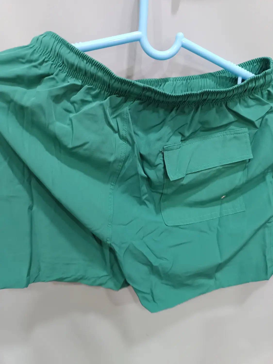 green printed men beach shorts with an elastic waistband and a single front pocket designed as summer swim trunks