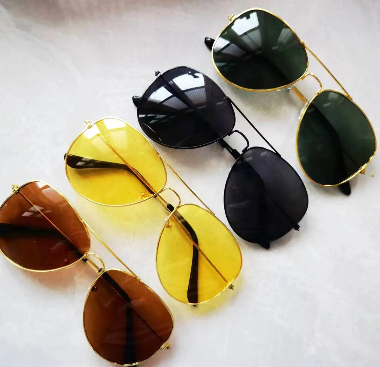 Set of five classic gold rimmed aviator uv protection sunglasses with gold metal frames and gradient tinted lenses in brown yellow black and green.