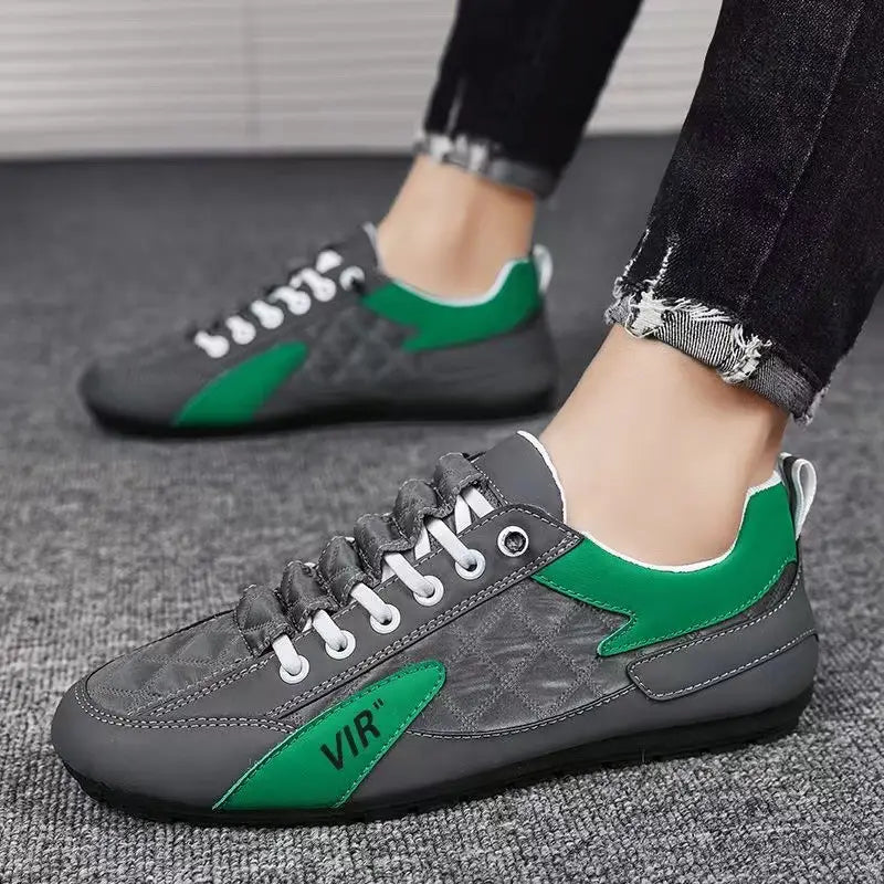 Men’s low top quilted athletic fashion sneakers in gray and green with quilted detailing white laces and vir logo on the side.