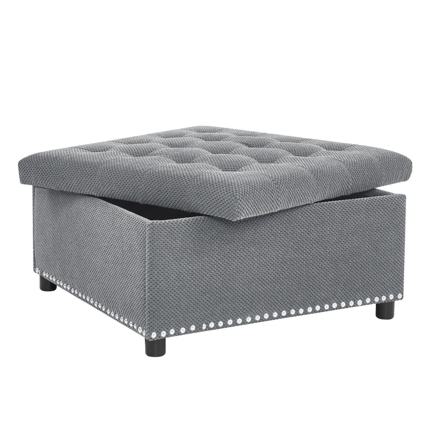 Gray tufted storage ottoman with textured fabric finish and decorative nailhead trim along the base.