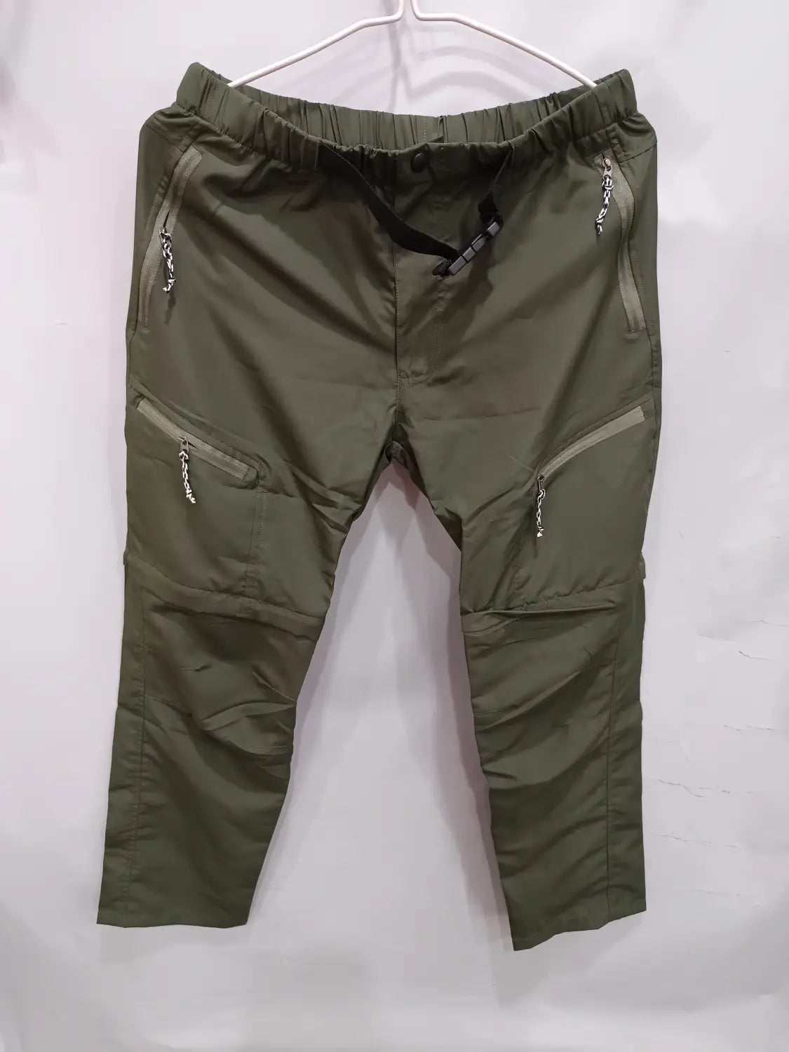 olive green convertible tactical hiking cargo pants with multiple zippered pockets and an elastic waistband designed for outdoor use