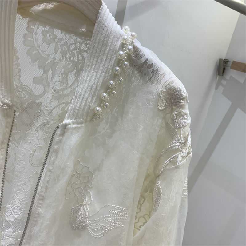 白い繊細なフローラル刺繍と、肩に沿ってパールのラインをあしらったアイボリーのレースパール刺繍ボンバージャケット。