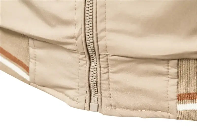 Beige quilted men’s bomber jacket featuring a central zipper and striped fabric accents on the sleeve for casual zip outerwear.