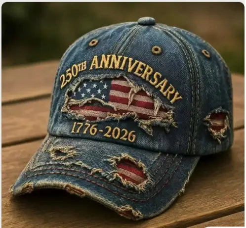 Distressed blue denim baseball cap featuring a torn American flag patch and 250th anniversary 1776-2026 embroidered in gold thread.