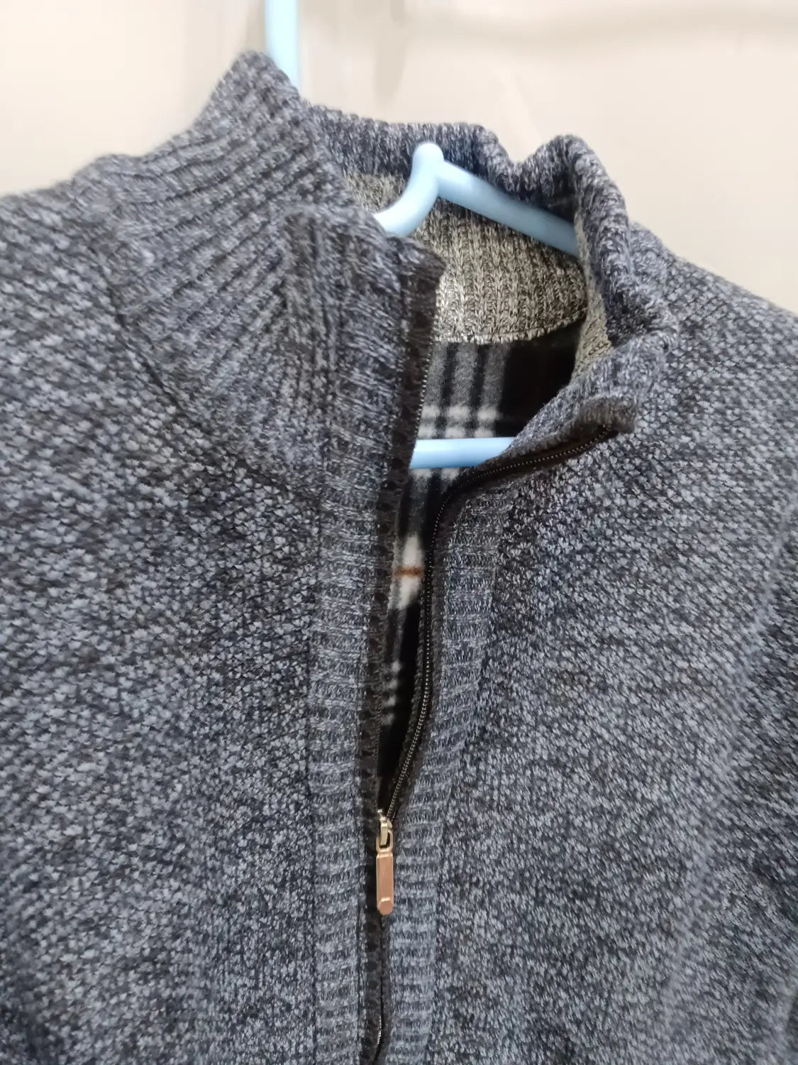 Herren-Cardigan mit Strukturstrick und Reißverschluss in Grau, mit geripptem Kragen und Karofutter, aus Strickmaterial gefertigt.
