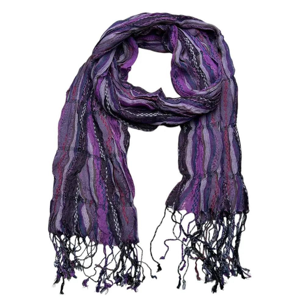 Une écharpe froissée en jacquard violet aux multiples tonalités, au tombé fluide, avec des rayures tissées complexes et des bords frangés, conçue comme accessoire d’hiver texturé.