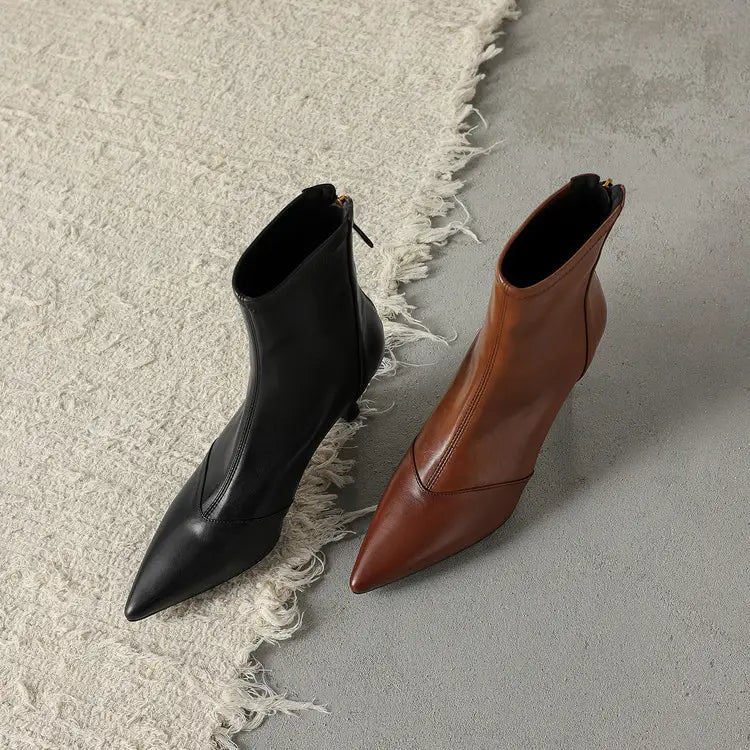 a pair of pointed toe cowhide stiletto ankle boots in black and brown leather with a subtle sheen and zipper closure