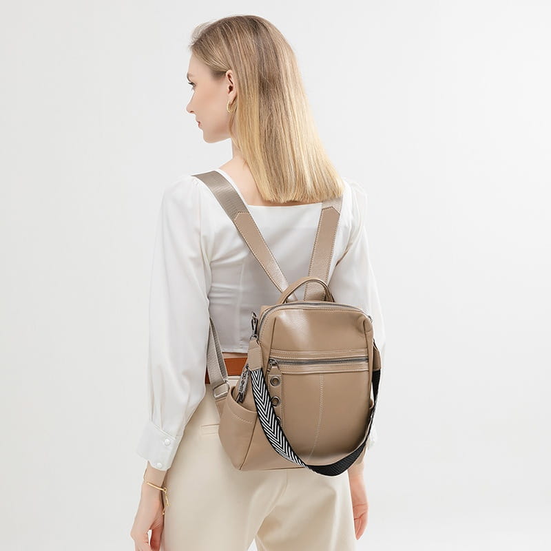 Beige urban faux leather backpack featuring a herringbone striped shoulder strap and a front zipper pocket.