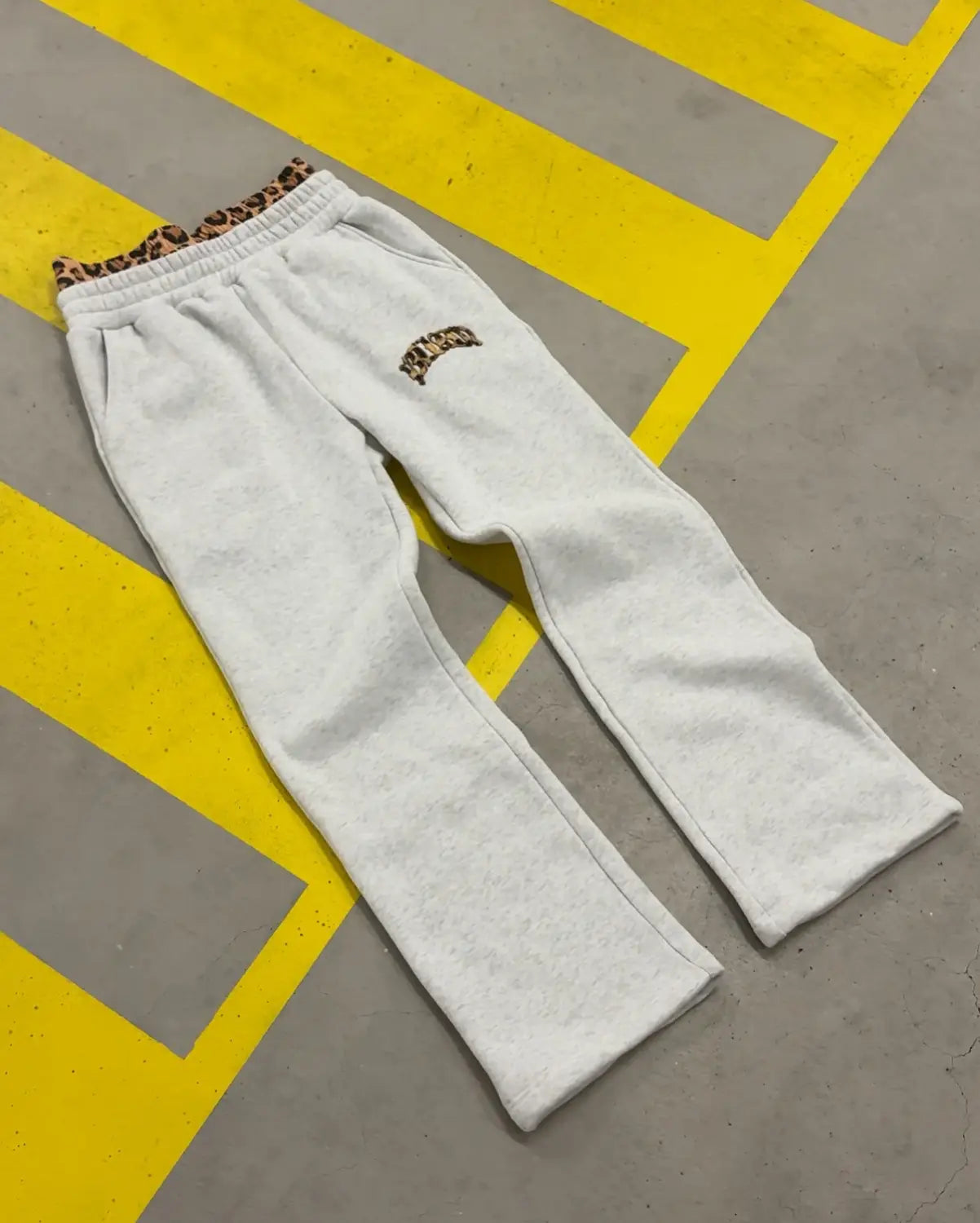 Jogging en molleton blanc avec une ceinture à imprimé léopard et un logo brodé assorti sur la cuisse, issu de l’ensemble sweat à capuche et jogging à imprimé léopard.