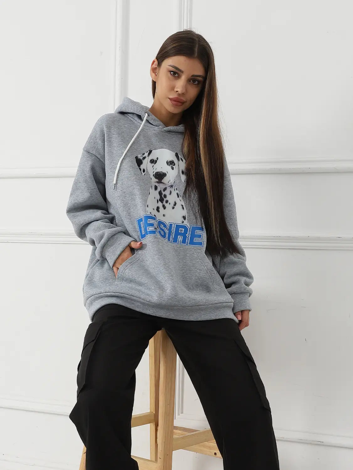 Gray women’s hoodie made of soft fabric featuring a printed dalmatian and the word desire in blue lettering with a cat ear hood.