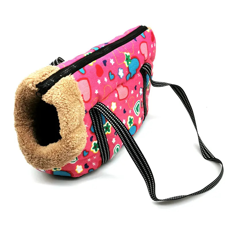 Warm pet carrier canvas fleece travel bag featuring a pink patterned exterior, plush tan lining, and black striped straps.