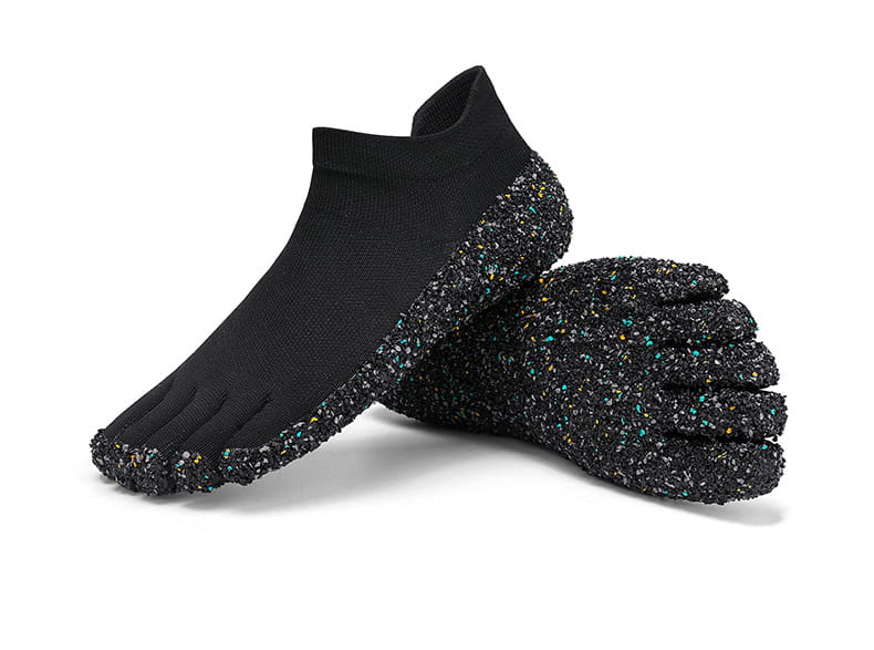Chaussures de natation et de randonnée à cinq doigts sans chaussures noires dotées de semelles en caoutchouc à motifs irréguliers texturées avec des touches colorées.