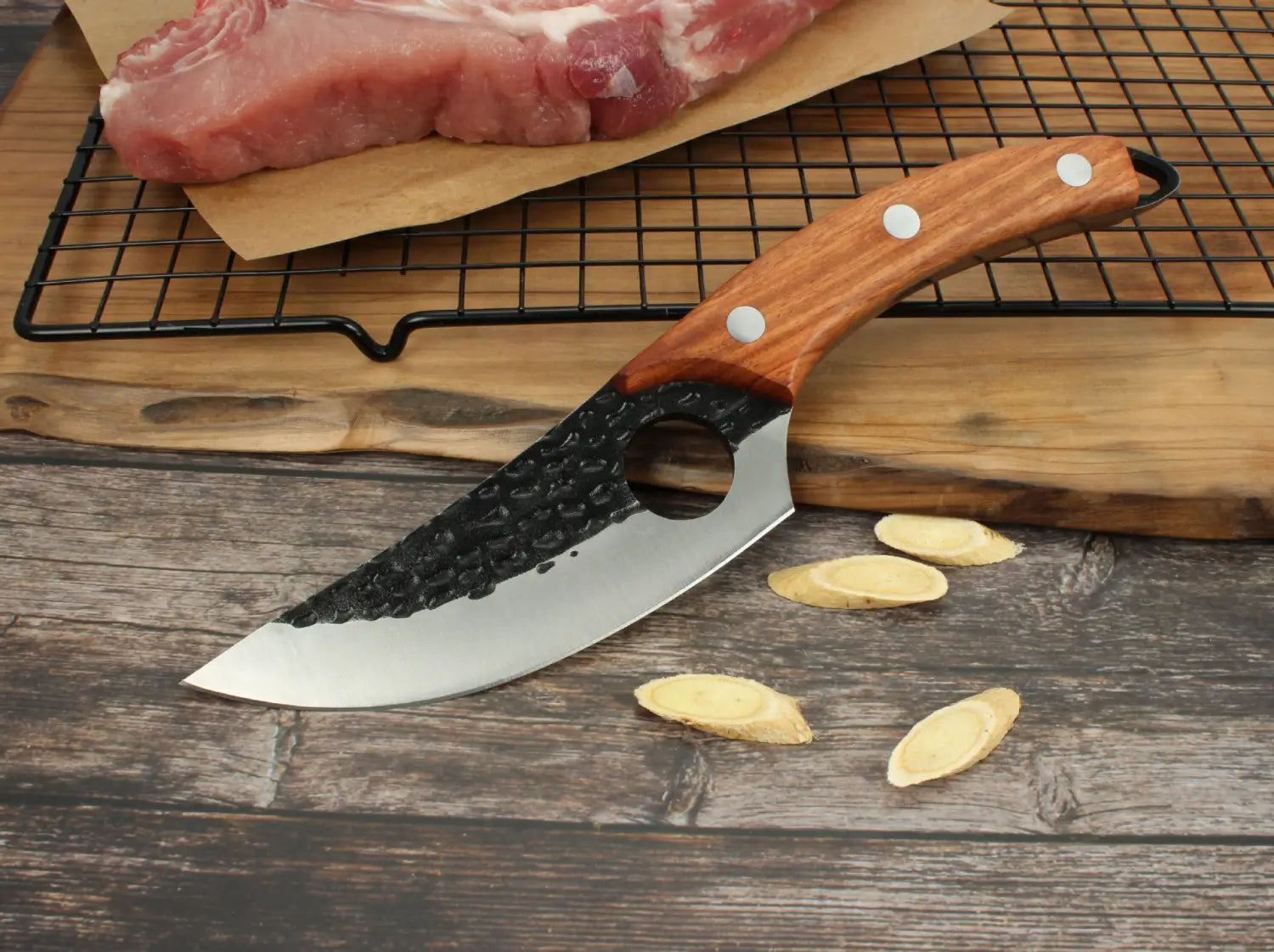 Un couteau à désosser rustique à manche en bois, doté d’une lame en acier au carbone à haute teneur forgé à la main noire et argent martelée, avec trois rivets blancs sur le manche et un étui.