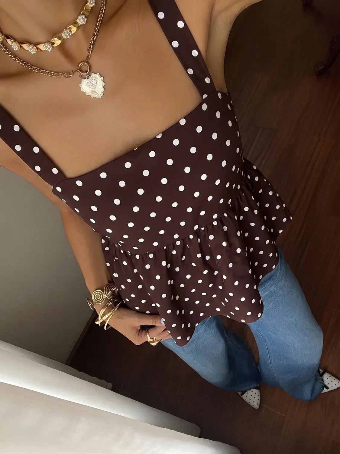 Brown polka dot peplum camisole featuring a ruffled design with white dots and thin straps.