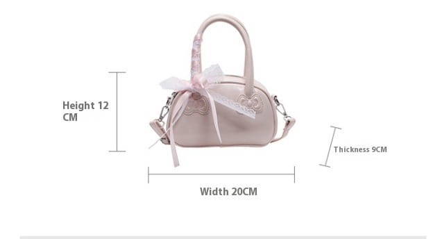 A soft pink glossy leather crossbody bag with a lace bow and decorative butterfly appliqués from Hello Kitty.