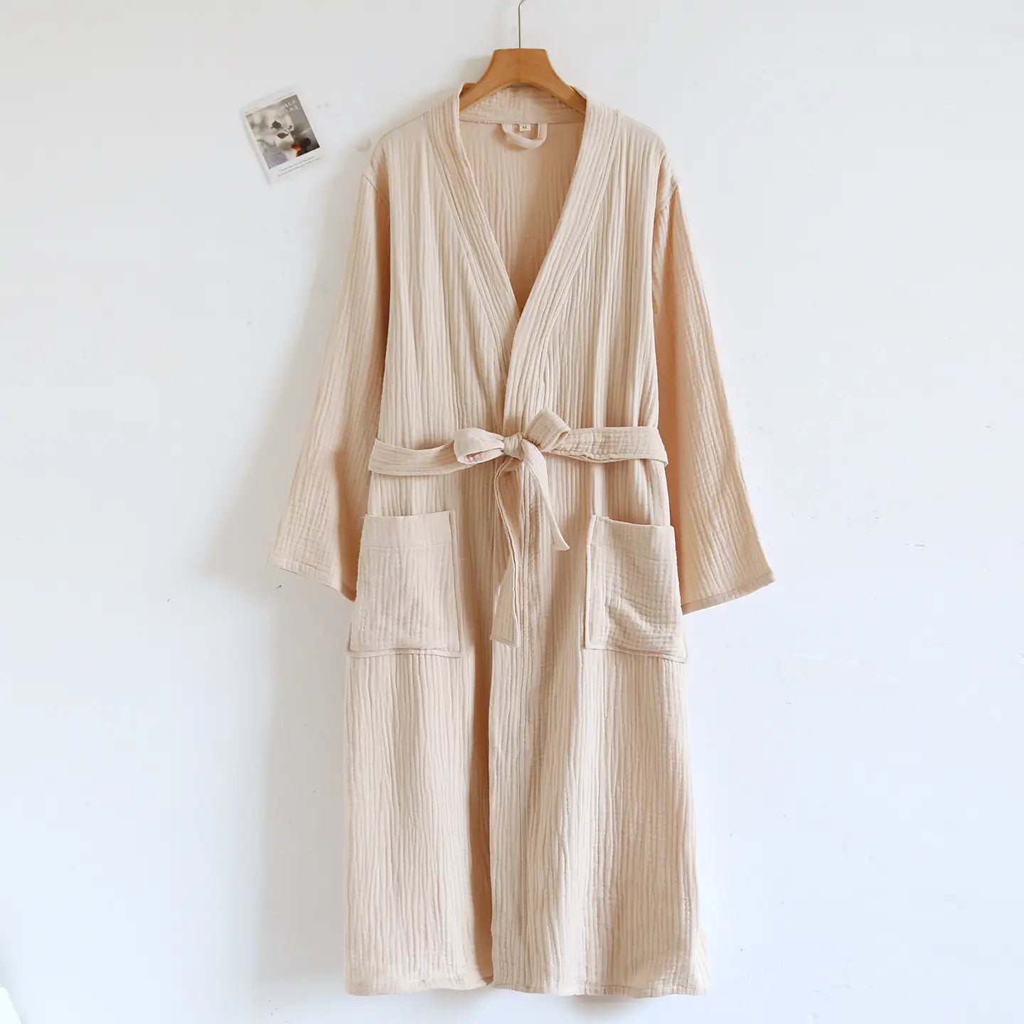 Peignoir en gaze de coton côtelé beige pour homme, avec une ceinture assortie nouée à la taille et deux poches avant.