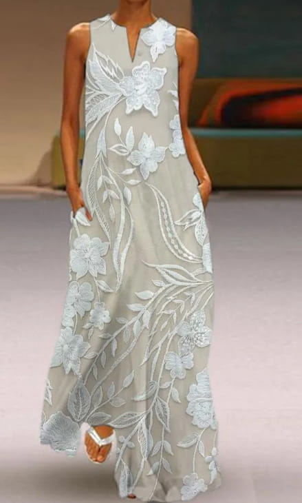 Robe longue maxi sans manches en dentelle florale appliquée élégante, en gris clair, avec une broderie florale blanche complexe et des motifs délicats de feuilles.