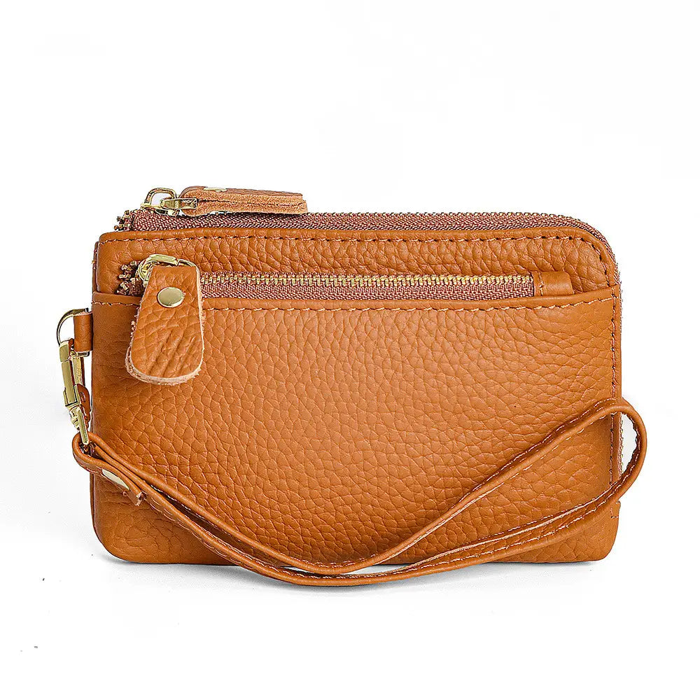 Premium textured leather wristlet wallet in tan pebbled leather with gold-tone zippers and a matching adjustable strap.