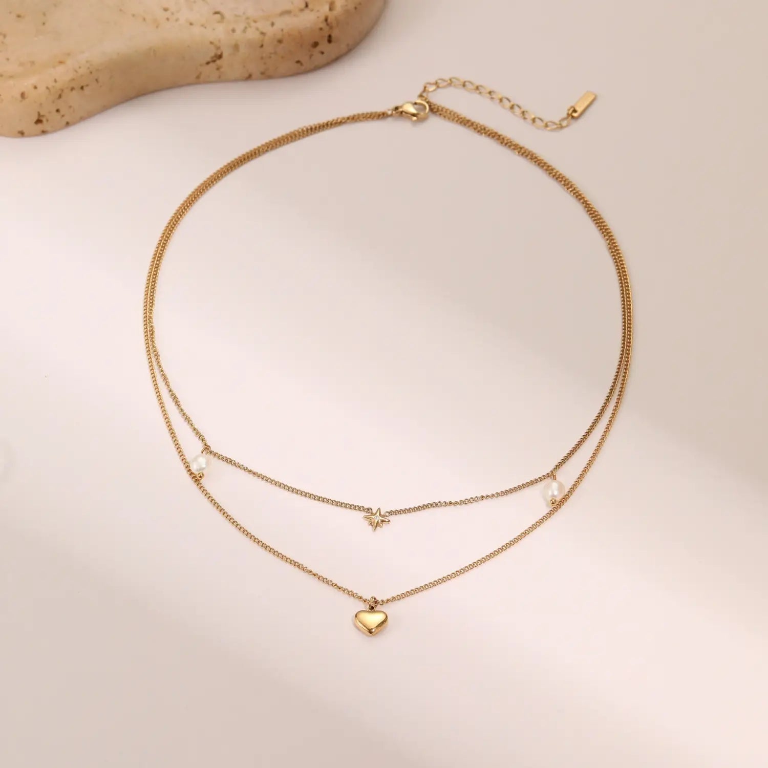 Double layer 18k gold stainless steel necklace featuring delicate gold-toned chains with a star charm, heart pendant, and tiny pearl accents.