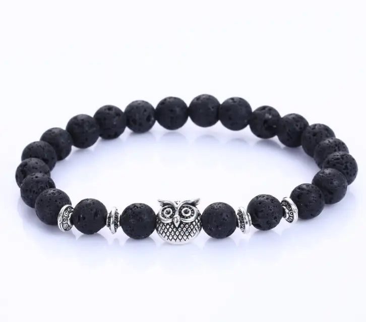 Black lava stone bracelet with a silver owl charm and decorative metallic spacers featured in a natural lapis lazuli and lava stone owl charm bracelet.