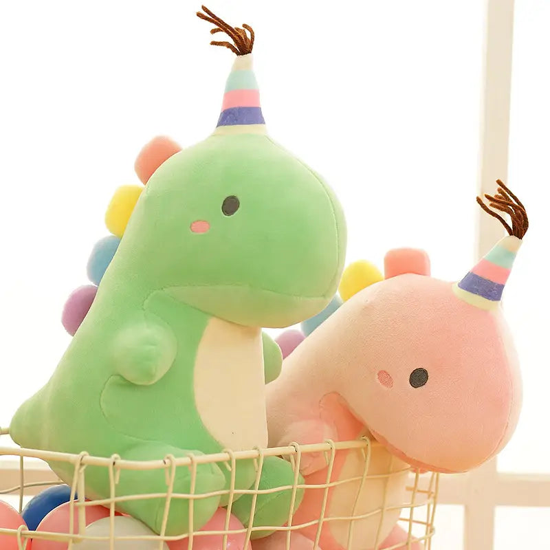 Niedliche grüne und pinkfarbene Dinosaurier-Plüschtierchen aus weichem Material mit bunten Partyhüten, geeignet als Kuscheltiere für Feiern
