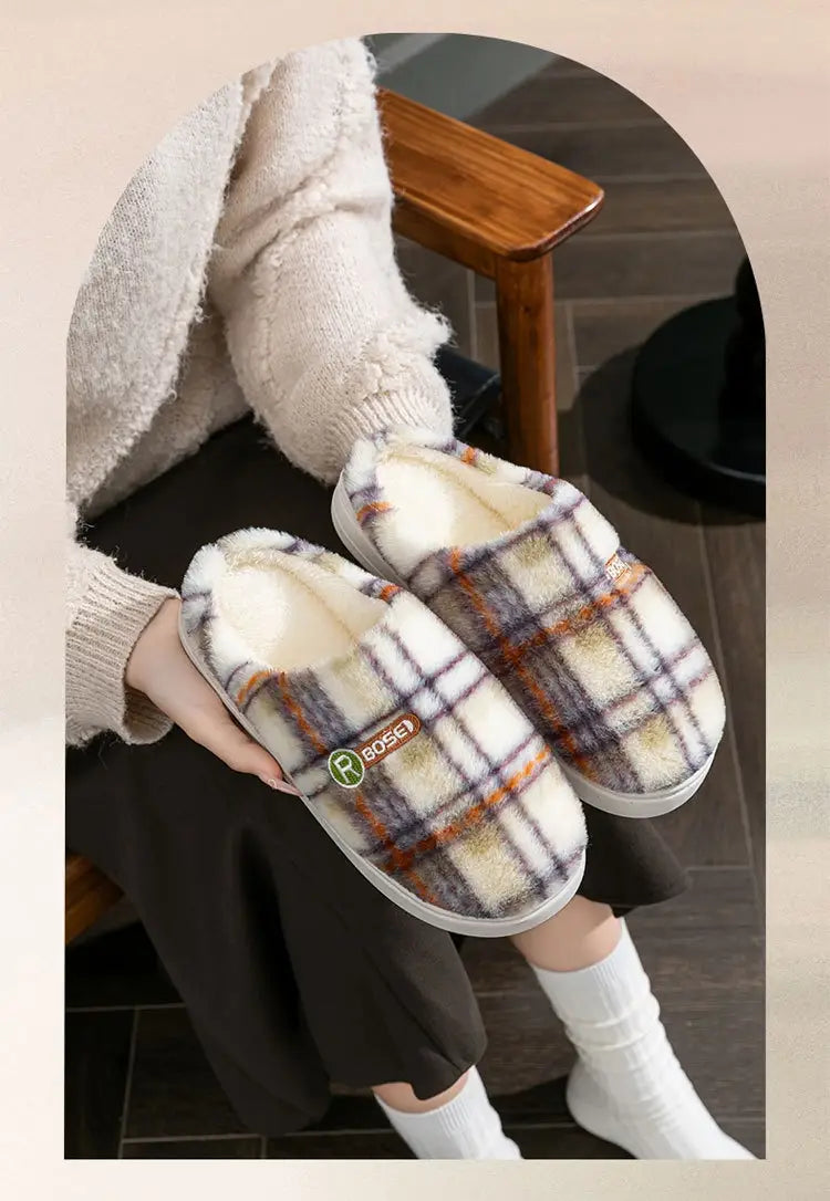 Unisex plaid fleece lined non slip indoor slippers featuring a soft white interior and an orange brown and cream check fleece exterior.