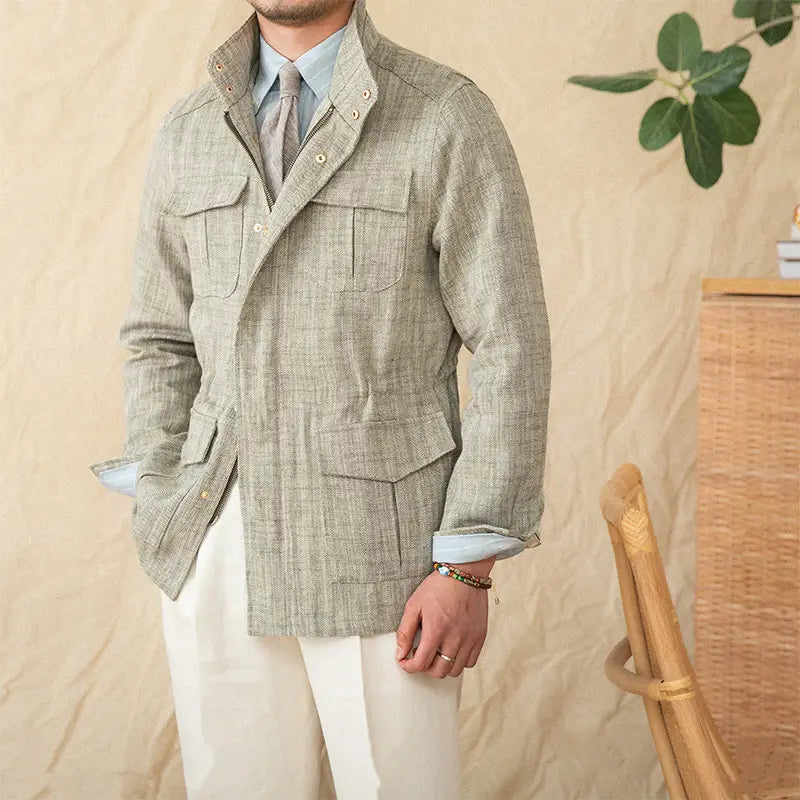 A light gray herringbone-patterned cotton linen m65 safari jacket featuring a notched collar and flap pockets.