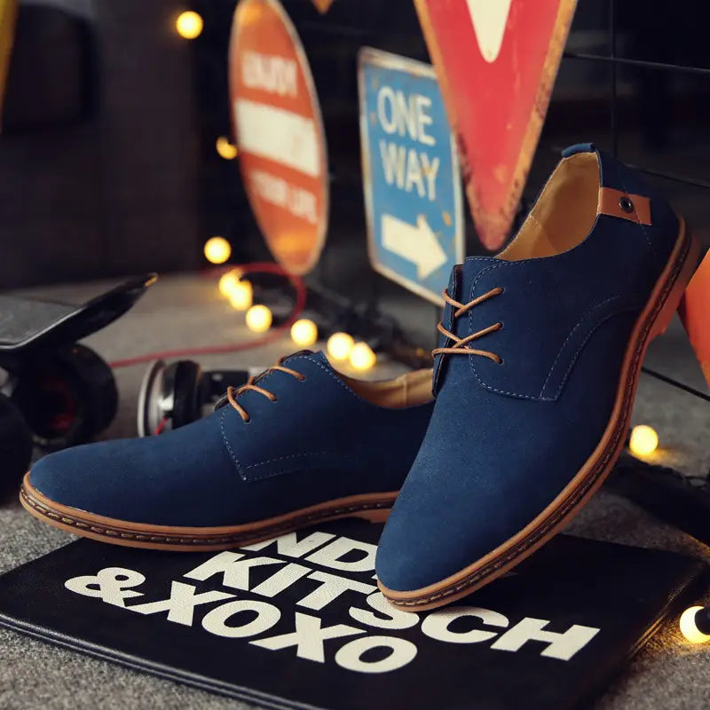 Dunkelblaue Wildleder-Schnür-Oxford-Schuhe für Herren mit beigen Lederschnürsenkeln und braunen Sohlen, als Leder-Flats gestaltet.