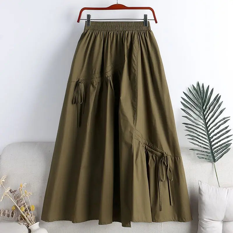 Jupe trapèze vert olive avec taille élastique, design à jambe large, poches latérales et liens à cordon de serrage réalisés dans un tissu doux.
