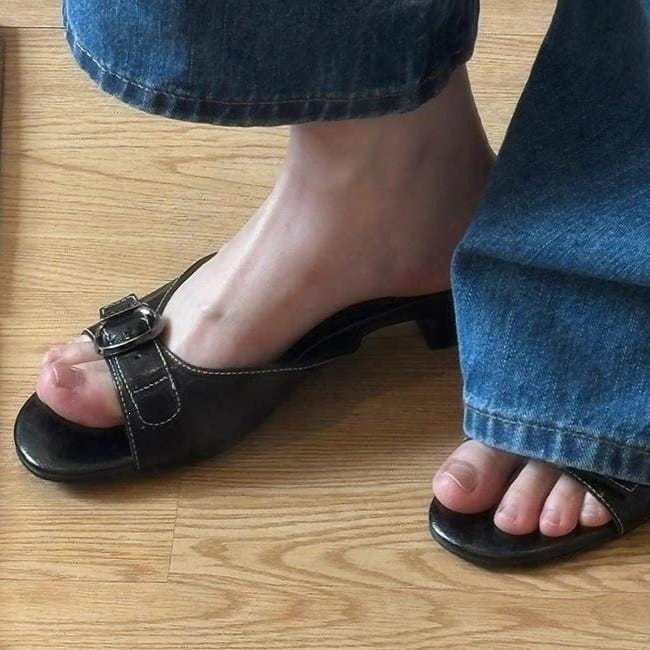 Sandalias tipo mule de cuero negro para mujer con puntera cuadrada, tacón bajo y correa con hebilla.
