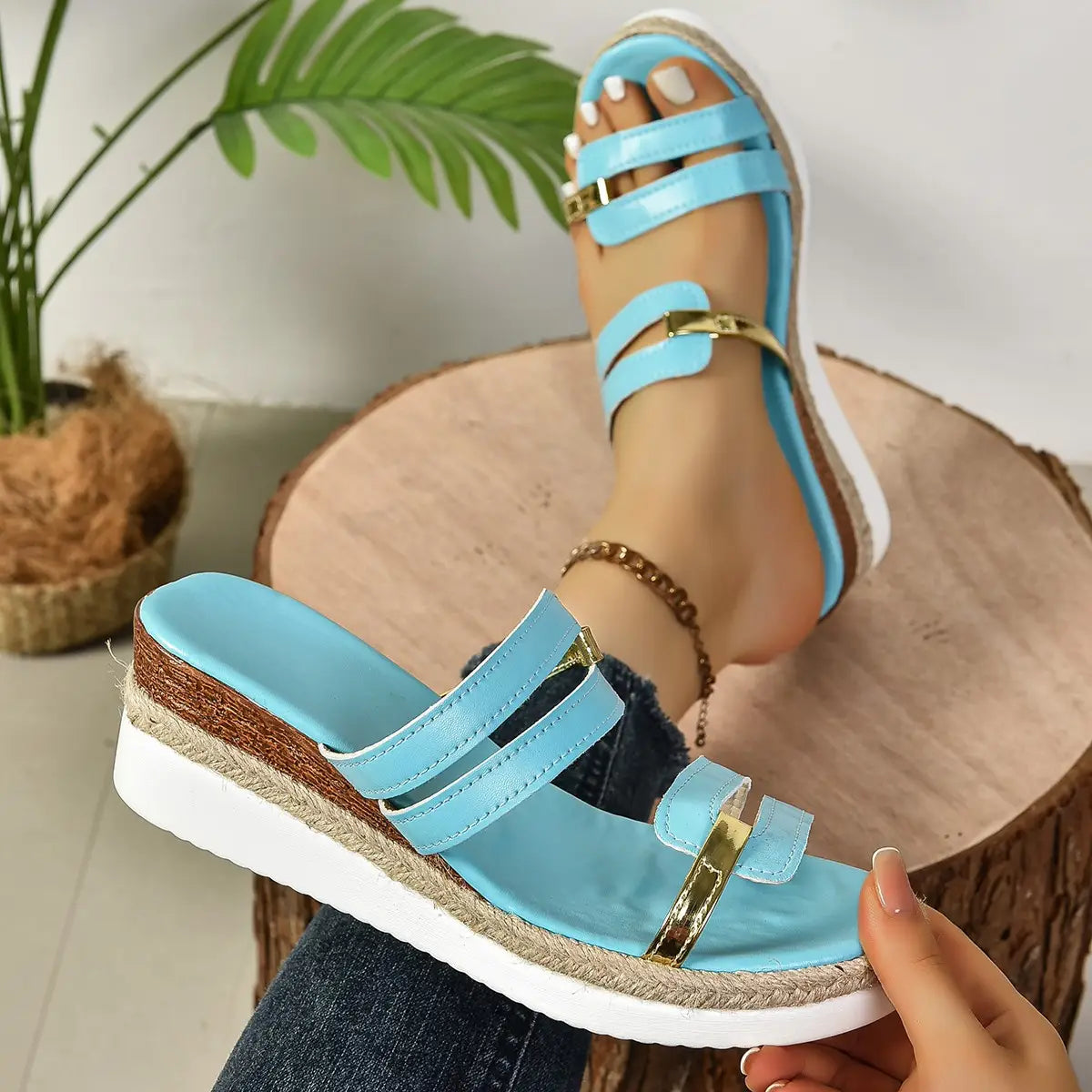 Light blue wedge sandals with espadrille heel and gold-tone metal accents featuring a woven sole.