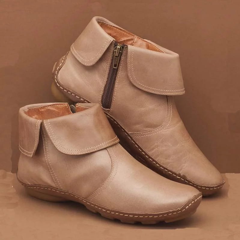 Beigefarbene Damenleder-Ankle-Boots mit seitlichem Reißverschluss und sichtbarer Steppnaht entlang der Kanten.