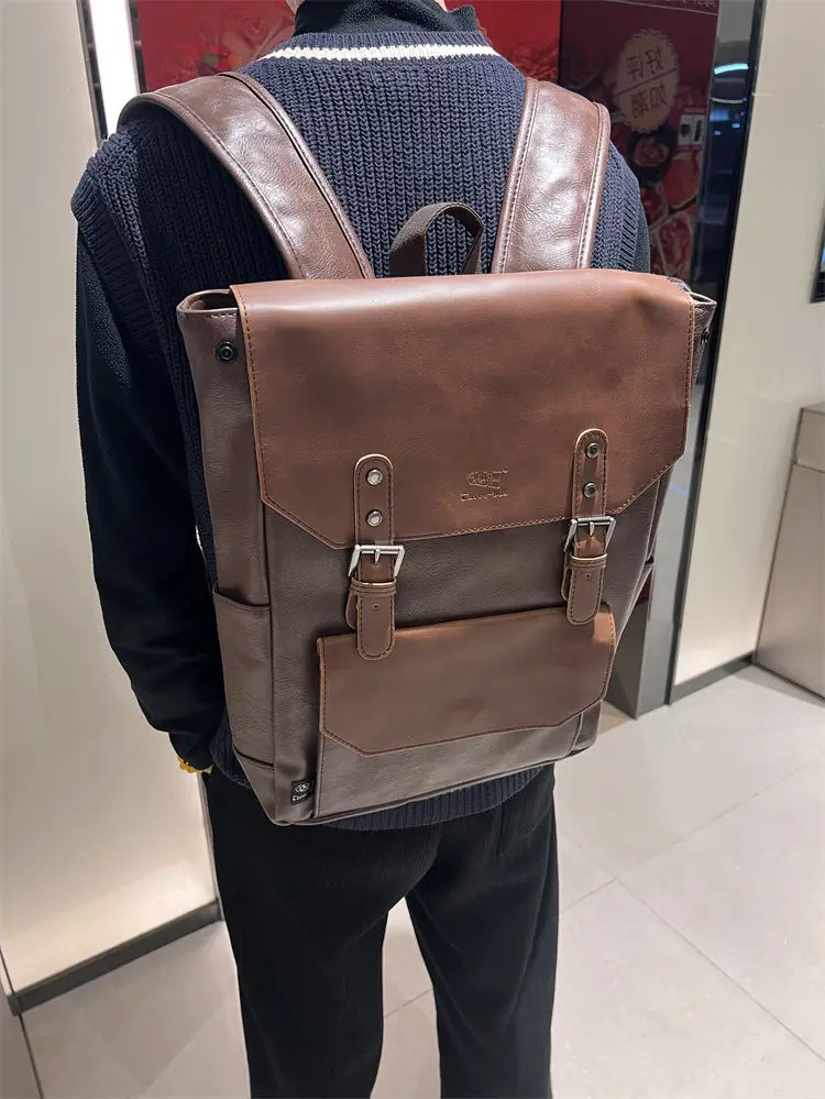 Brown leather backpack with a classic flap design and silver-toned metal buckles for vintage leather college backpack large capacity travel bag.