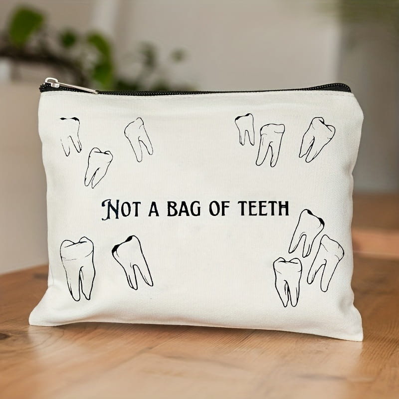White canvas tooth pouch with black tooth illustrations and the text not a bag of teeth printed on the front designed as a travel makeup case.
