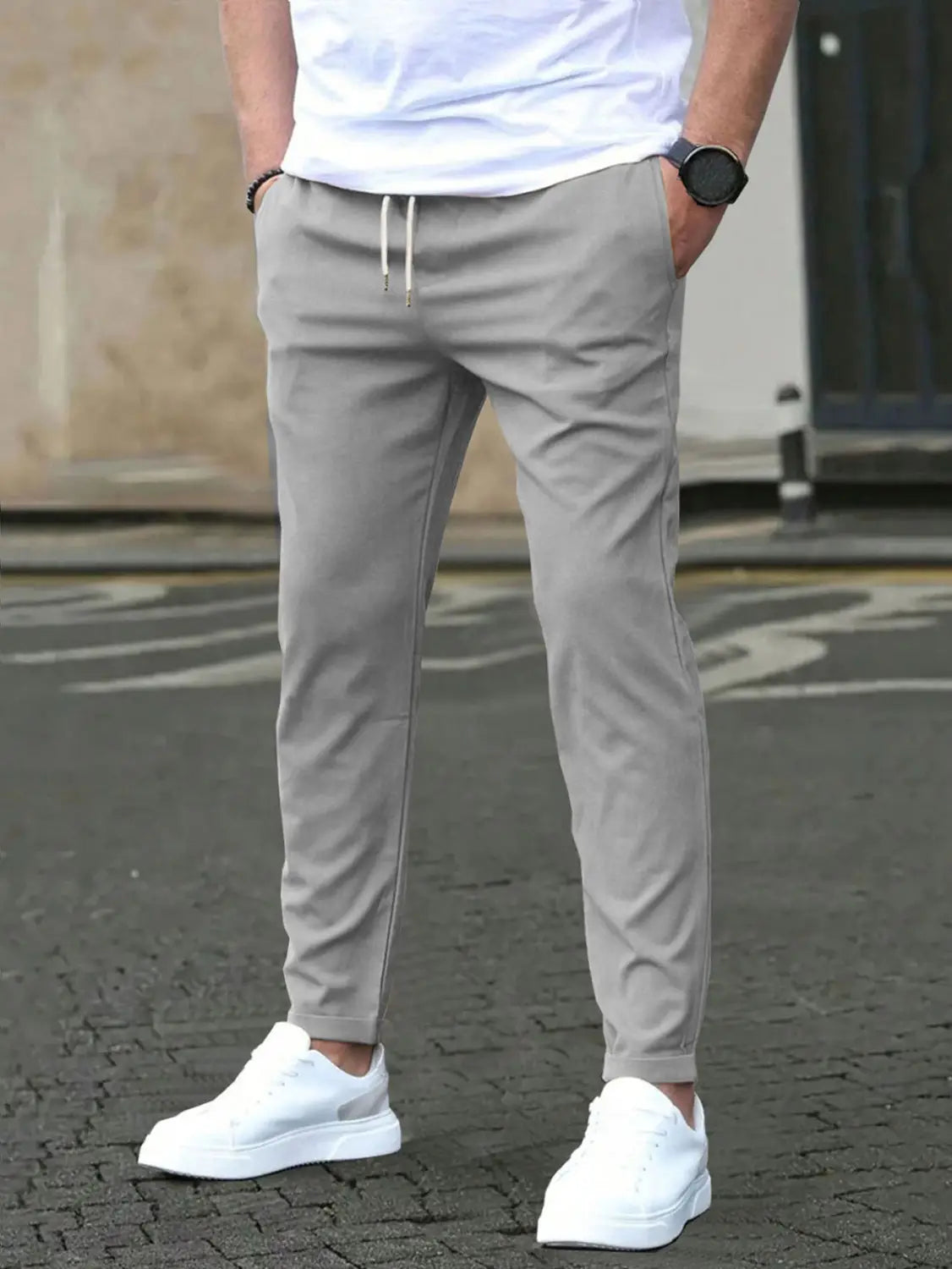 Gray slim fit tapered jogger pants with drawstring featuring a sleek fit and subtle white cord detailing.